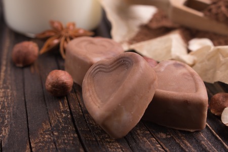 Chocolate heart-shaped candy on a rustic backgroundの写真素材