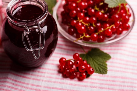 fresh red currant and jam on the rustic background.