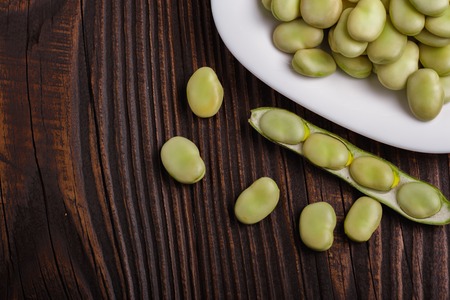 fresh broad beans on a rustic background.