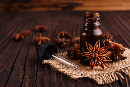 essential oil of the anise stars on a dark rustic background.の写真素材