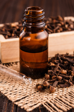 essential oil of cloves on a wooden rustic background.の写真素材