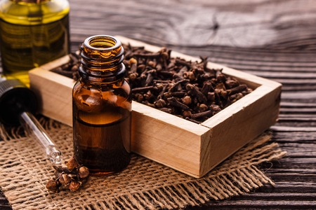 essential oil of cloves on a wooden rustic background.の写真素材