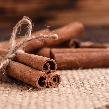 Cinnamon essential oil on a wooden background.