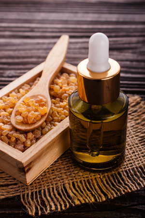 frankincense essential oil on a wooden background.の写真素材