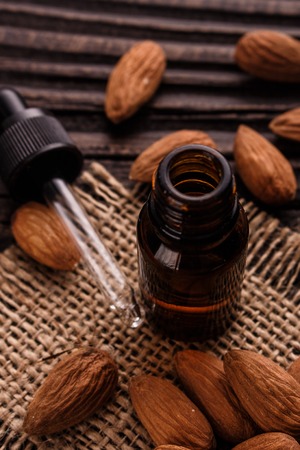 almond essential oil on a wooden background.の写真素材
