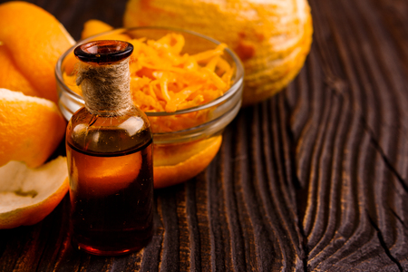 orange essential oil on a wooden background.の写真素材