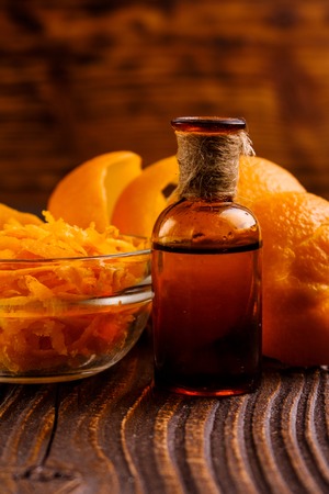 orange essential oil on a wooden background.の写真素材