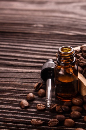 essential oil of coffee beans on a wooden background.の写真素材