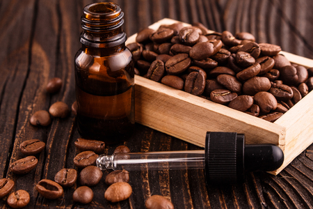 essential oil of coffee beans on a wooden background.の写真素材