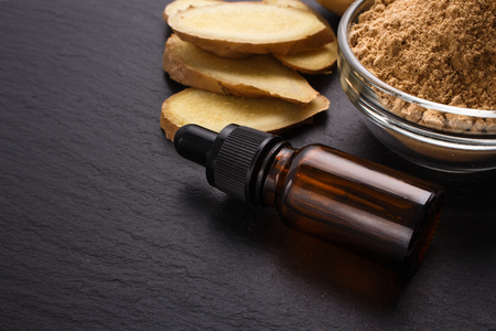 Ginger root essential oil on a dark background.の写真素材