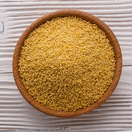 bowl of millet on a white wooden background.の写真素材