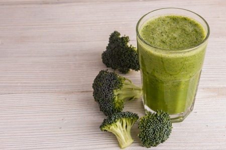 fresh broccoli juice on a wooden background.の写真素材