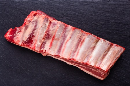 fresh lamb meat on a textured stone plate.