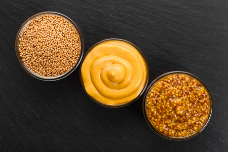 Set of different species of mustard on a rustic background.の写真素材