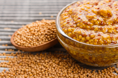 mustard in a bowl on a rustic background.の写真素材