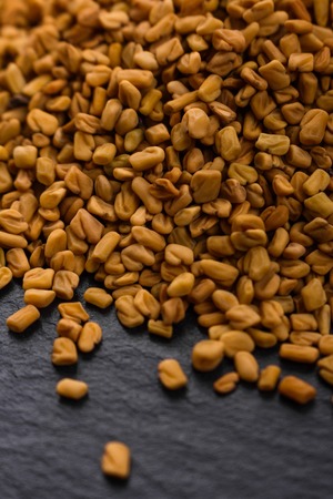 fragrant grains of fenugreek on a rustic background.の写真素材