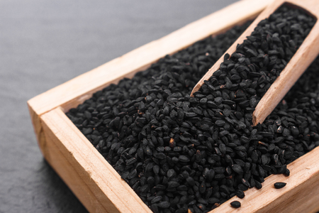 grains of black cumin and oil on the rustic background.の写真素材