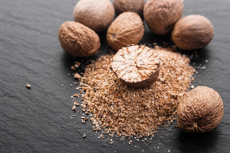 aromatic nutmeg on a dark stone background.の写真素材