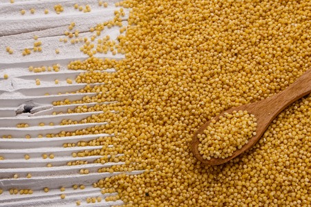 bowl of millet on a white wooden background.の写真素材