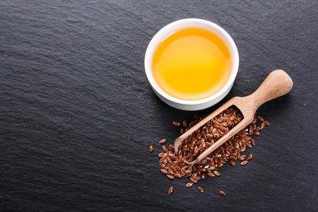 flaxseed and oil on a rustic background.の写真素材