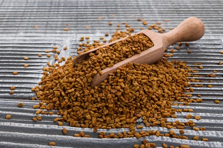 fragrant grains of fenugreek on a rustic background.の写真素材