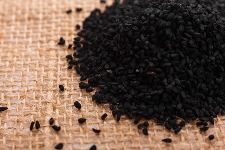 grains of black cumin and oil on the rustic background.の写真素材
