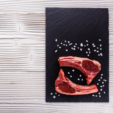 fresh lamb meat on a textured stone plate.の写真素材