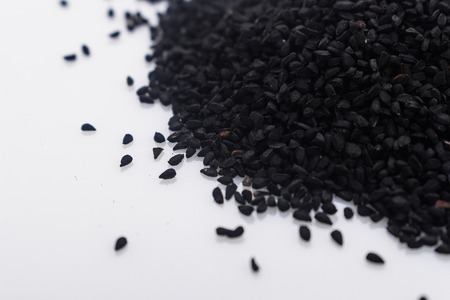 grains of black cumin and oil on the rustic background.の写真素材
