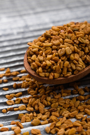 fragrant grains of fenugreek on a rustic background.の写真素材