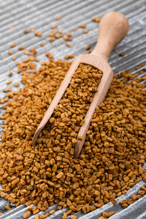 fragrant grains of fenugreek on a rustic background.の写真素材