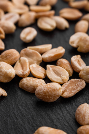 fresh peanuts on a dark stone background.の写真素材