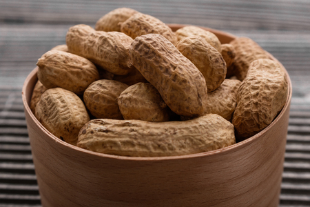 fresh peanuts on a wooden rustic background.