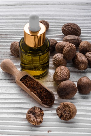 nutmeg essential oil on a gray wooden background.の写真素材