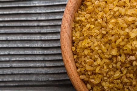 raw bulgur on a rustic wooden background.の写真素材