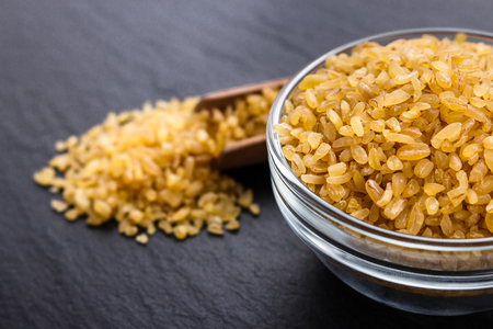 raw bulgur on a dark stone background.の写真素材