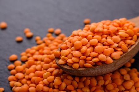 raw lentils on a dark stone background.