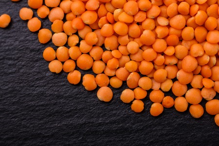 raw lentils on a dark stone background.の写真素材