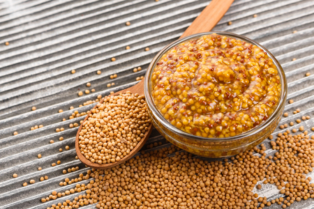 mustard in a bowl on a rustic background.の写真素材
