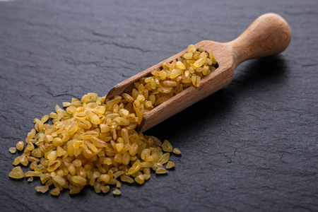 raw bulgur on a dark stone background.の写真素材