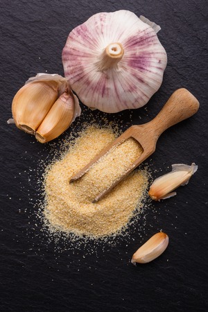 Fragrant garlic on a dark stone background.の写真素材