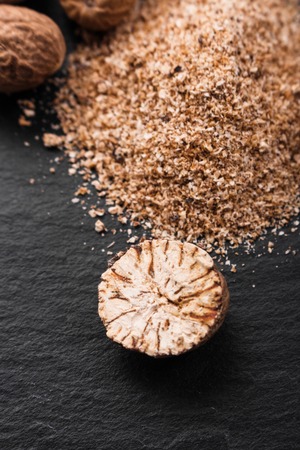 aromatic nutmeg on a dark stone background.の写真素材