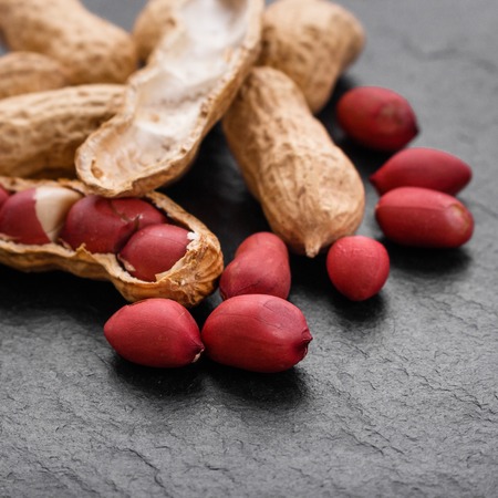fresh peanuts on a dark stone background.の写真素材