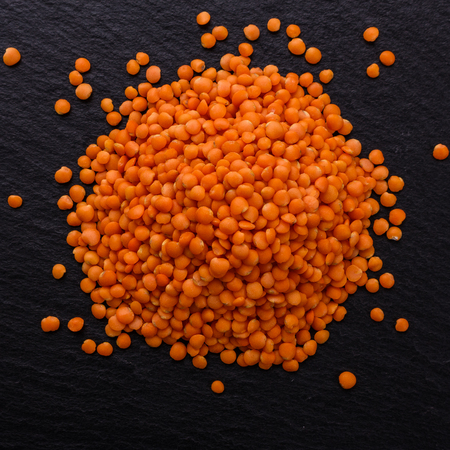 raw lentils on a dark stone background.の写真素材