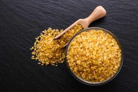 raw bulgur on a dark stone background.の写真素材
