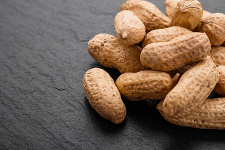 fresh peanuts on a dark stone background.の写真素材