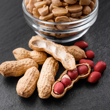fresh peanuts on a dark stone background.の写真素材
