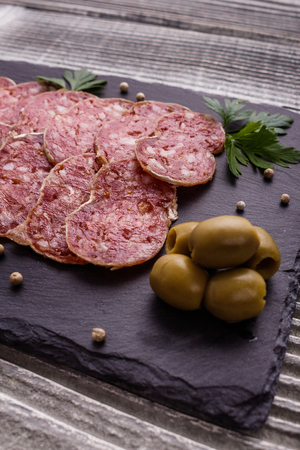 Saucisson sec delicious french salami on a wooden background.の写真素材