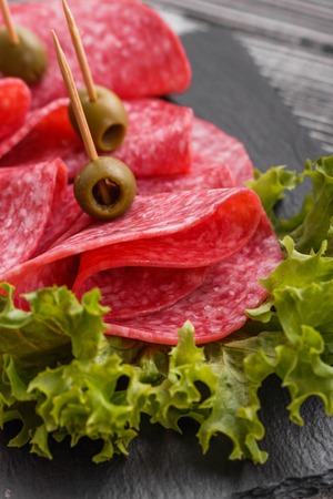 delicious sliced salami on a stone plate.の写真素材