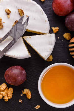delicious creamy camembert cheese on a wooden rustic background.の写真素材