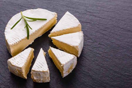 delicious creamy camembert cheese on a wooden rustic background.の写真素材